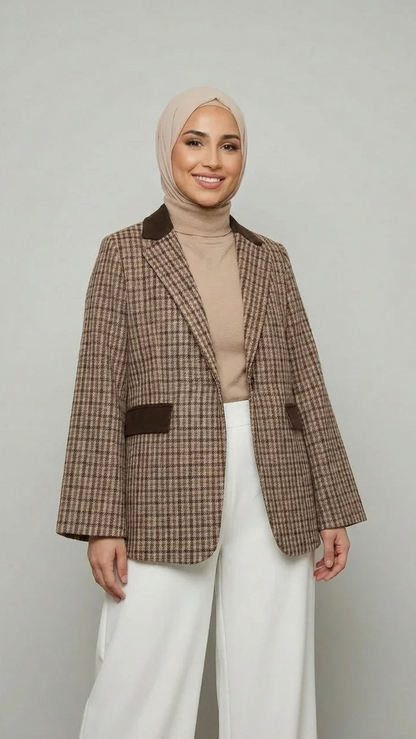 Femme souriante en blazer à carreaux Muneera, hijab beige et pantalon large blanc, mode modeste élégante.