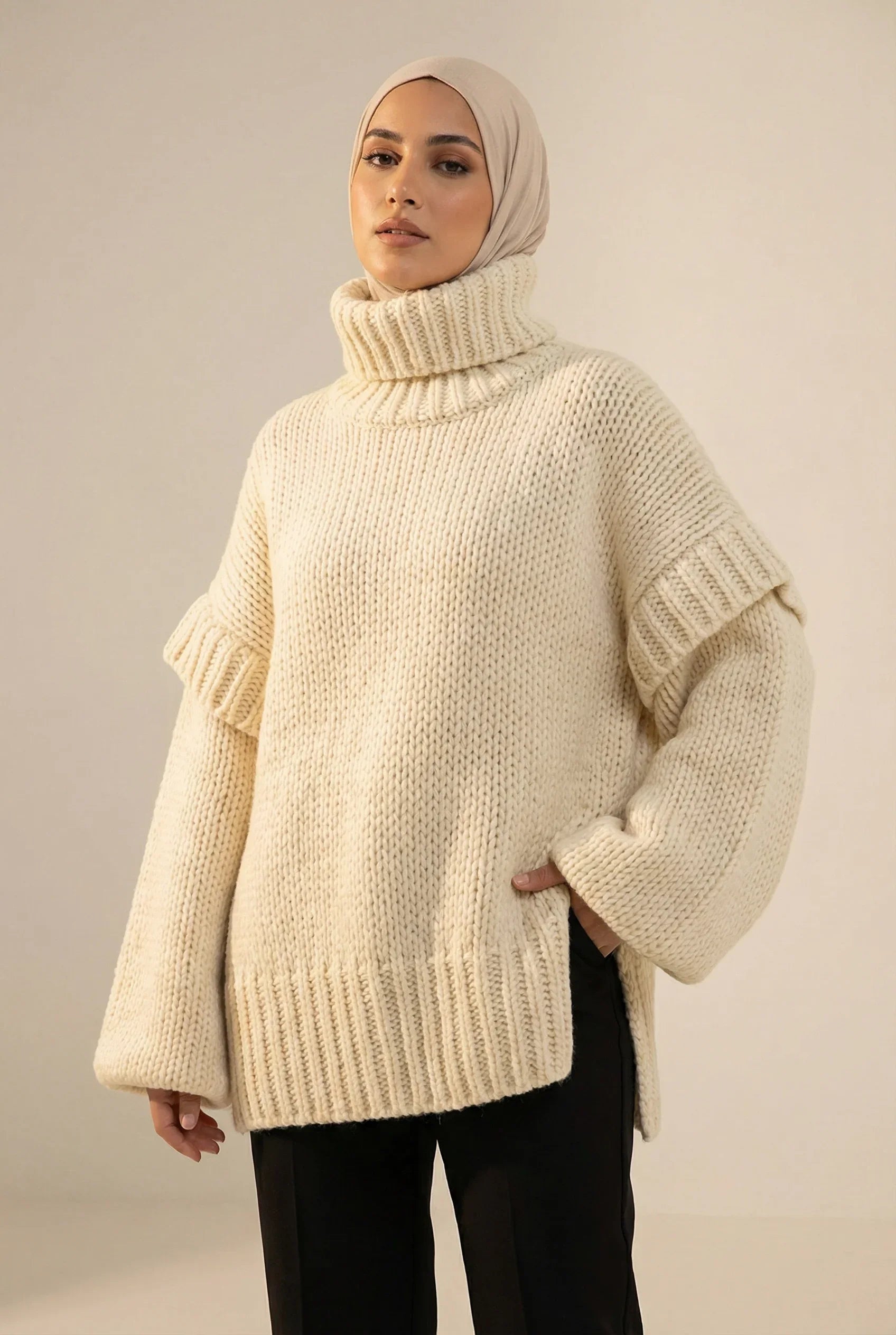 Femme portant un pull oversize tricoté crème avec col roulé, mode modeste Muneera