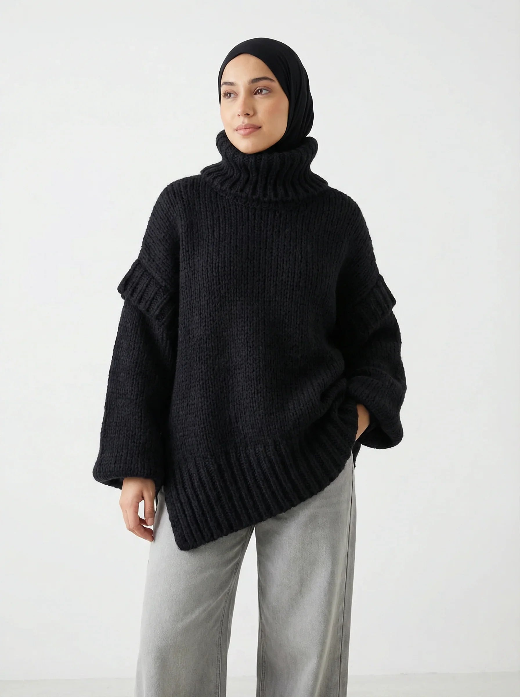 Femme portant un pull noir en maille épaisse Muneera, style mode modeste élégant.