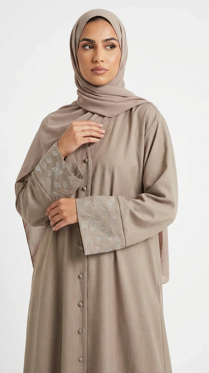 Femme musulmane portant une abaya beige élégante avec broderies, mode modeste Muneera