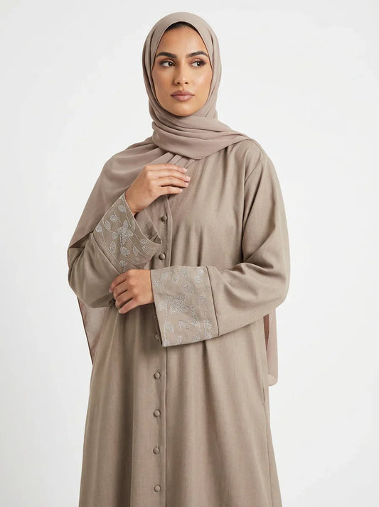 Femme musulmane portant une abaya beige élégante avec broderies, mode modeste Muneera