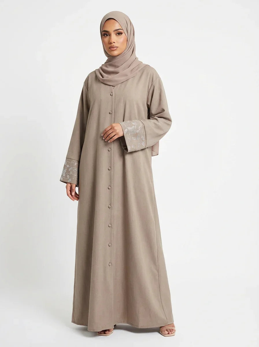 Femme en abaya taupe élégante Muneera, mode modeste, manches brodées, hijab assorti