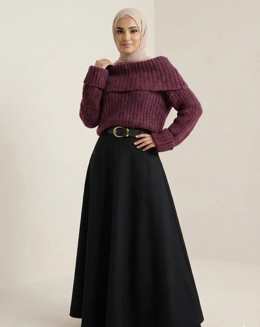 Femme portant un pull violet ample, jupe noire longue et hijab beige, mode modeste Muneera.