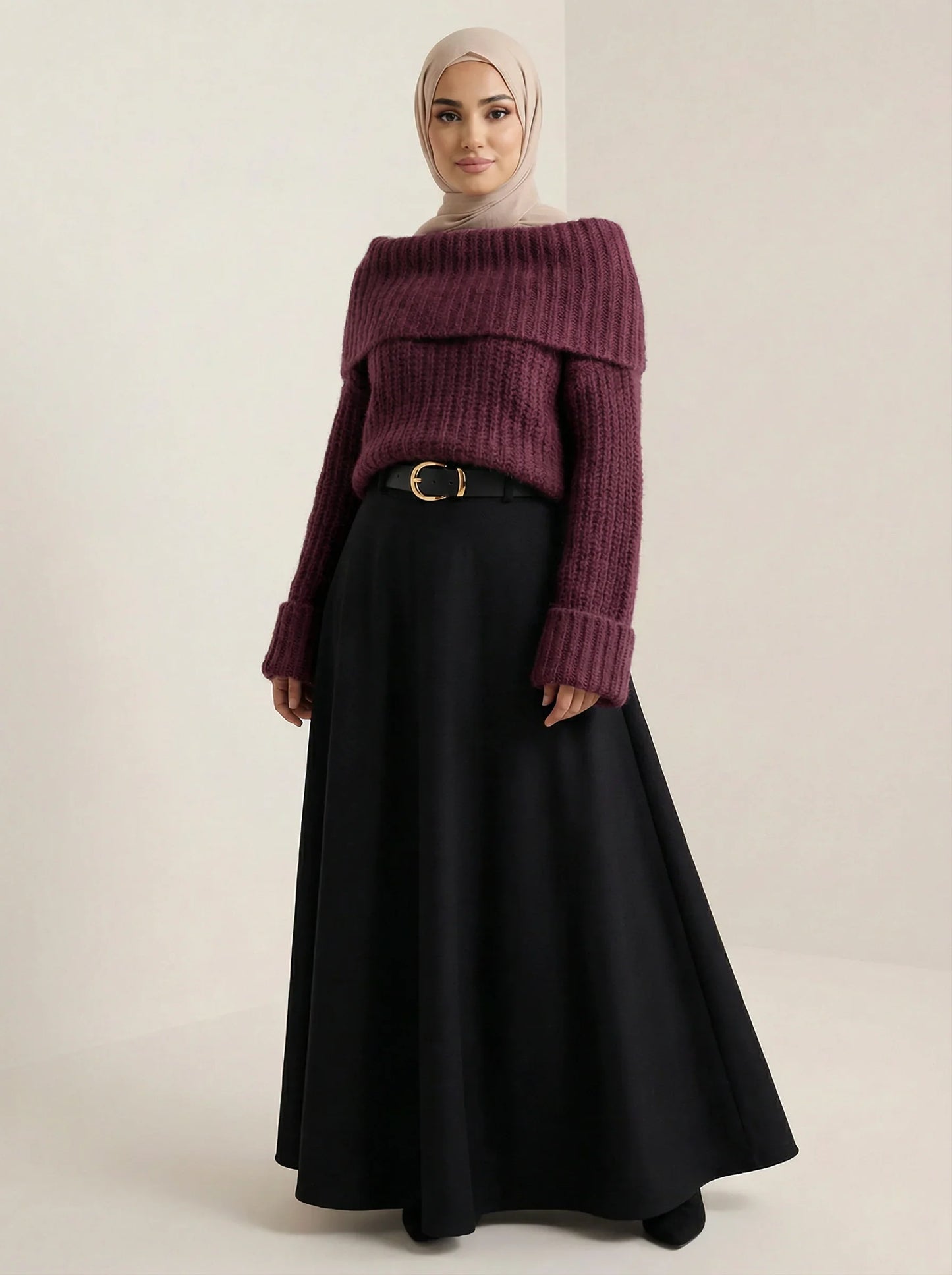 Femme portant un pull violet ample, jupe noire longue et hijab beige, mode modeste Muneera.