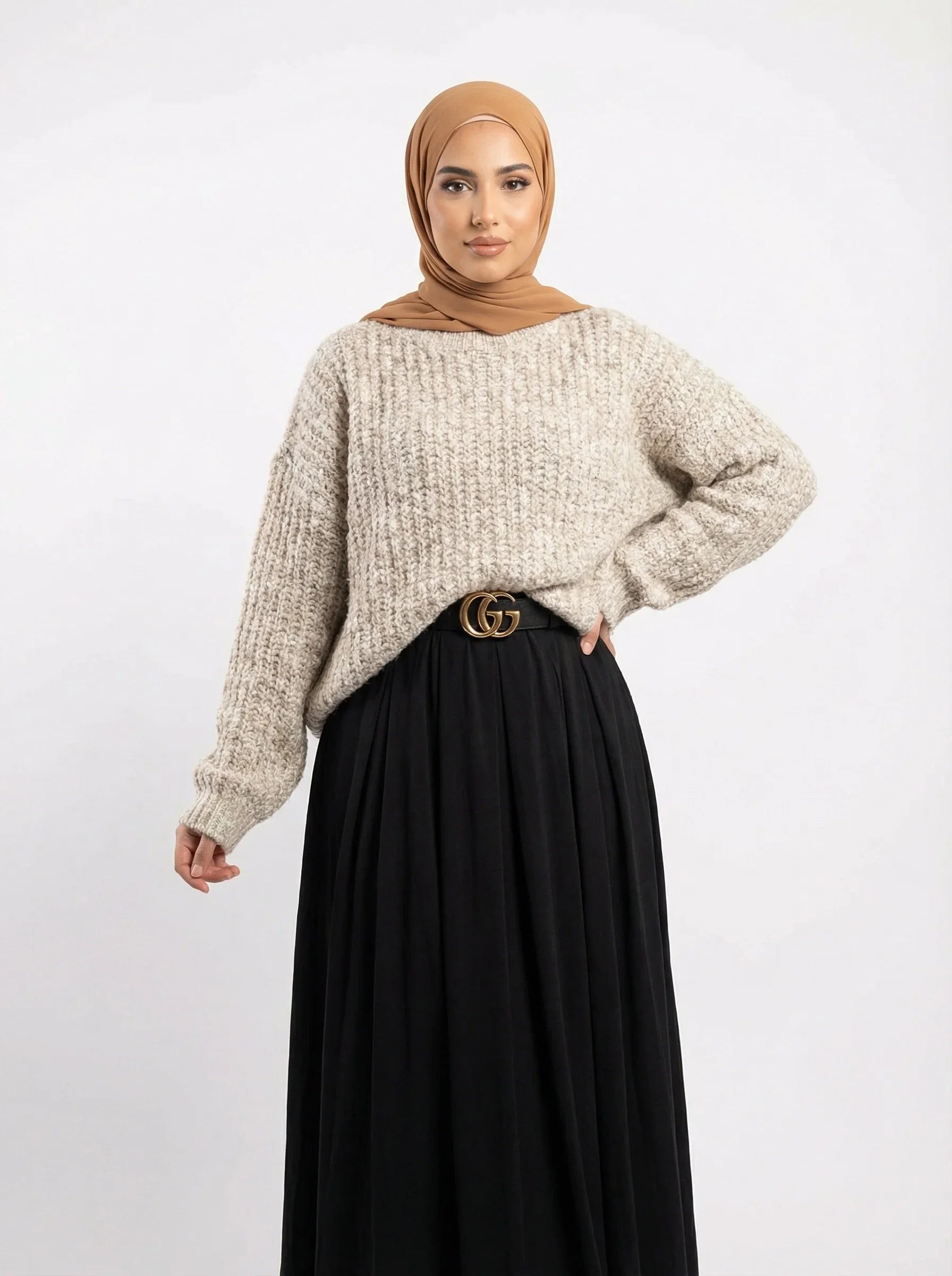 Femme en hijab beige, pull oversize beige et jupe noire longue, mode modeste Muneera.