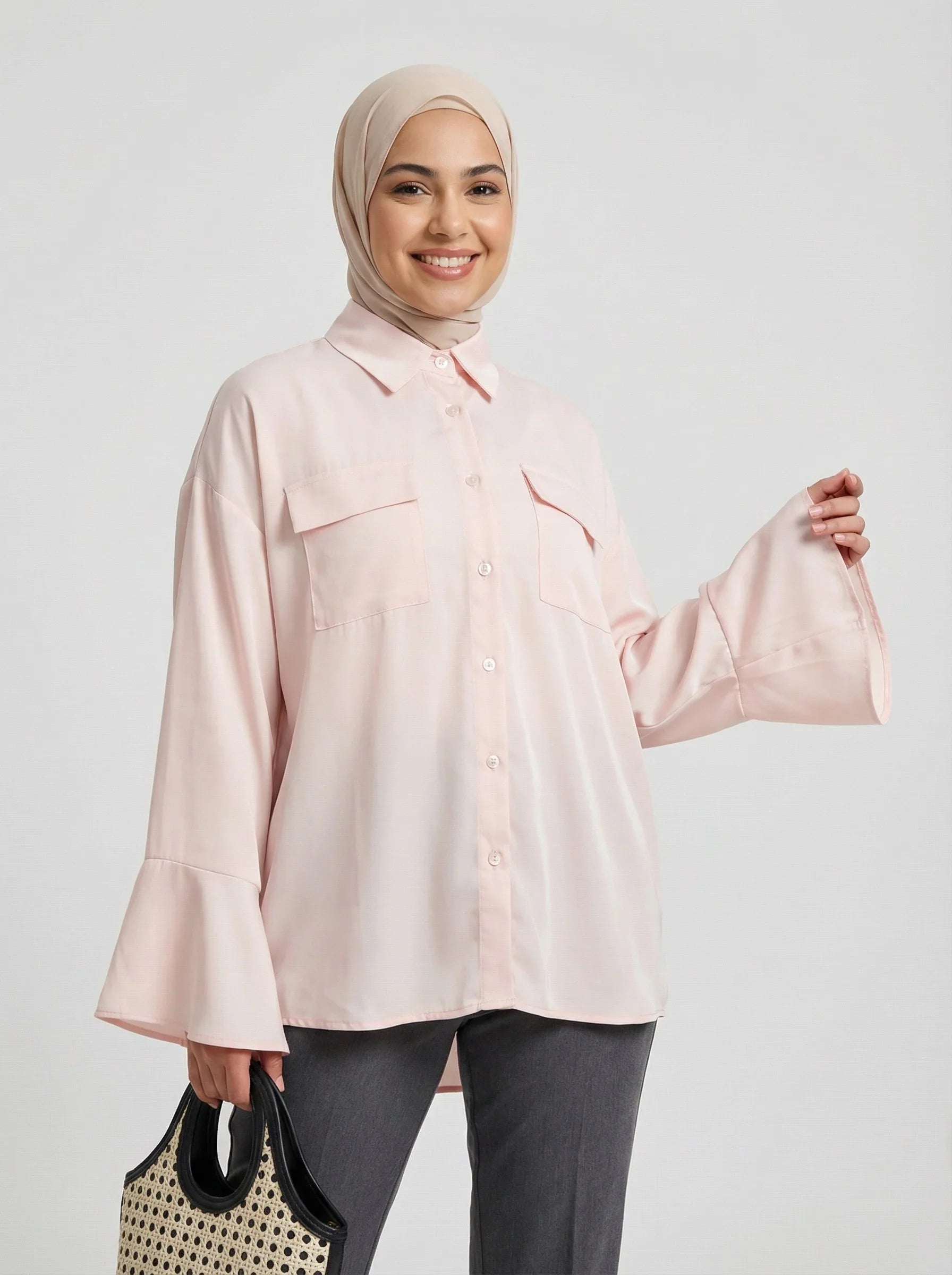 Femme souriante portant un hijab beige et une chemise longue rose Muneera, style mode modeste.