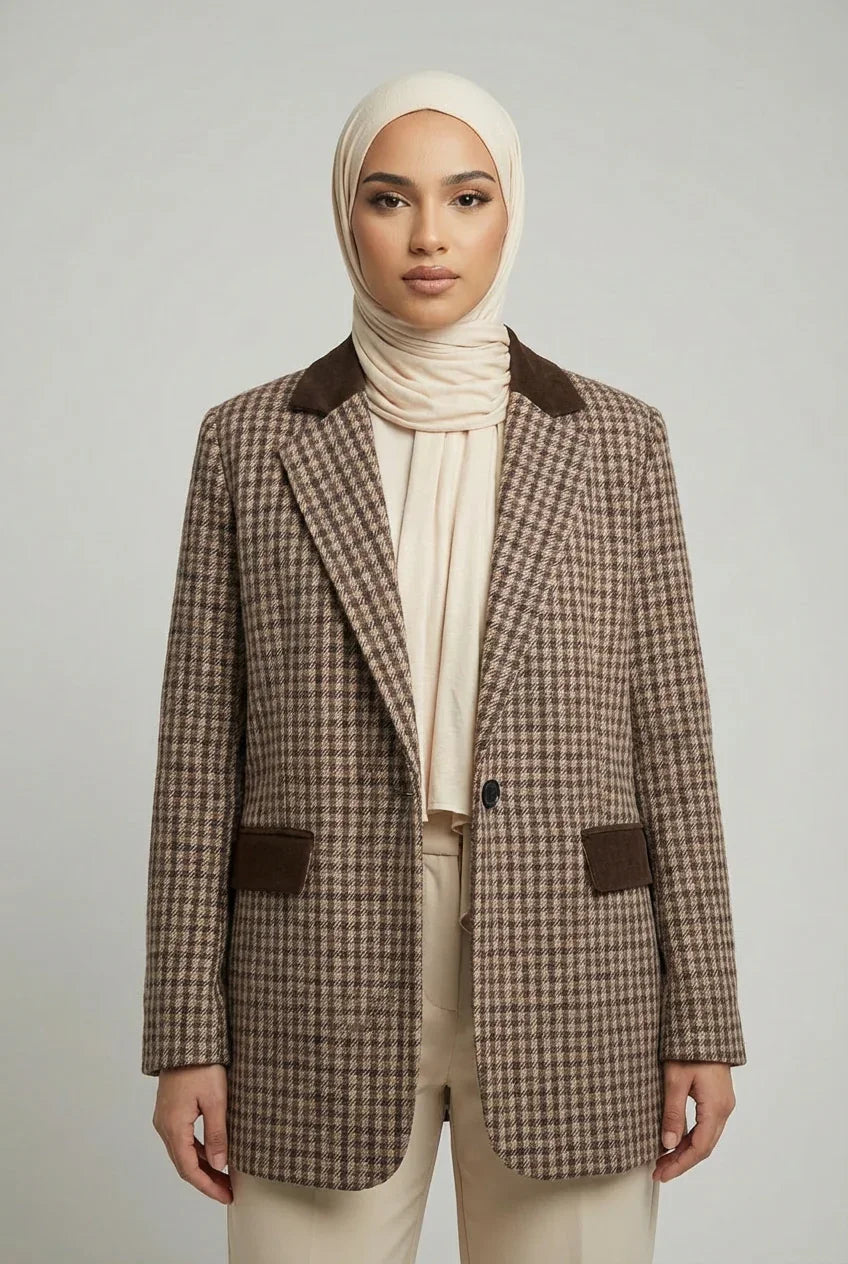Femme souriante en blazer à carreaux Muneera, hijab beige et pantalon large blanc, mode modeste élégante.